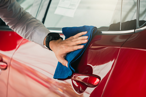 Hombre asiática inspección y limpieza equipo de lavado de coches con el coche rojo para la limpieza a la calidad al cliente en el showroom de automóviles de transporte de servicio de automóviles imagen automotriz. photo
