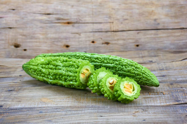 istock Bitter melon , Bitter gourd isolated on wood background. 1151363317