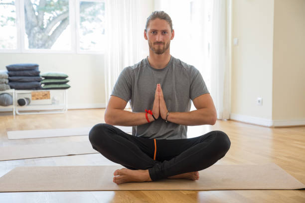 istock Serious man keeping hands together at yoga class 1151364642