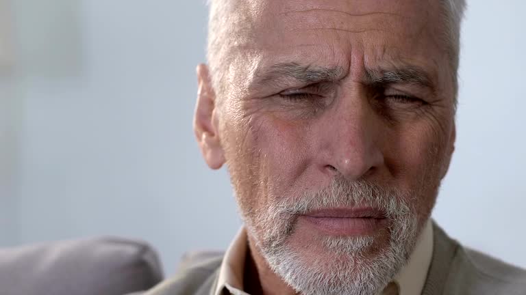 Elderly male putting hand on ear, hearing disabilities, deafness, close-up