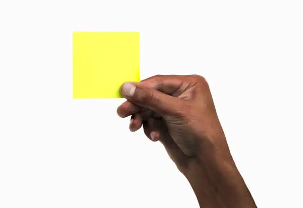 Cropped shot of an unrecognizable man hand holding a yellow notepaper on a white isolated background