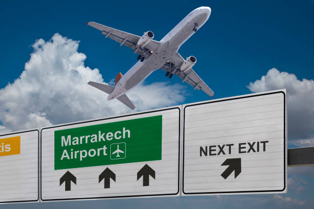 Road sign indicating the direction of Marrakech airport and a plane that just got up. Road sign indicating the direction of Marrakech airport and a plane that just got up. landing craft stock pictures, royalty-free photos & images