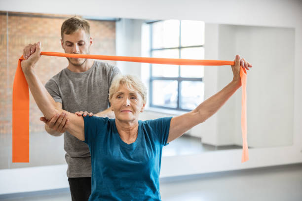 istock Senior woman doing resistance band workout with coach 1151368719