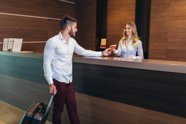 istock Nice friendly woman talking to the client while standing at the reception 1151368944