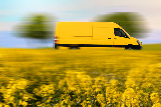 Fast parcel delivery, yellow mail van on country road. stock photo