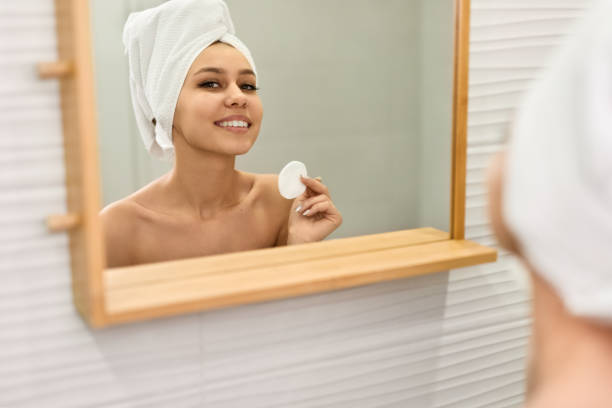 istock Smiling lady performing skincare routine near mirror 1151370757