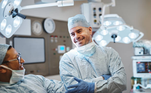 Maintaining good rapport with peers is part of professionalism Shot of two happy surgeons talking in an operating room doctor and hospital stock pictures, royalty-free photos & images