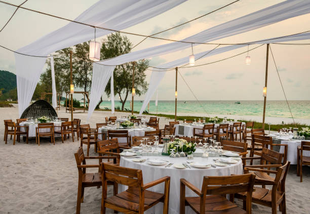 romántico diseño de la mesa de bodas al atardecer en la playa asiática tropical en bali indonesia - boda playa fotografías e imágenes de stock