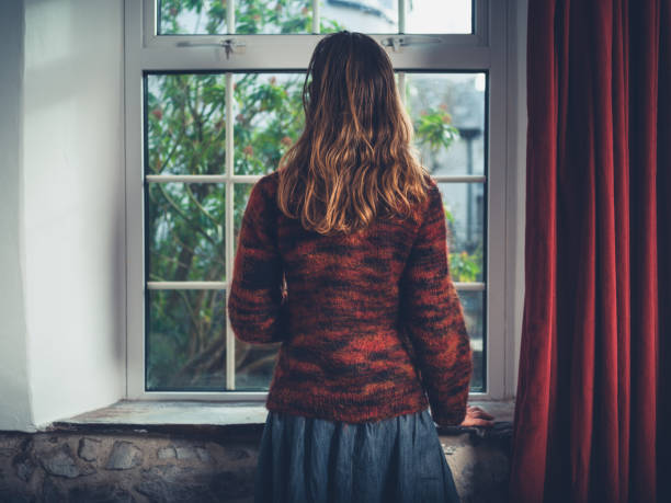 istock Young woman looking out the window 1151376399