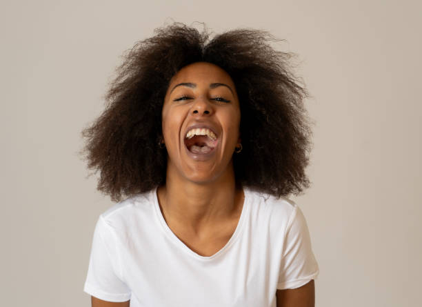 ritratto ravvicinato di attraente donna afroamericana con bel sorriso e capelli afro. isolato su sfondo neutro. in persone, espressioni facciali umane positive ed emozioni. - hairstyle human hair women human face foto e immagini stock