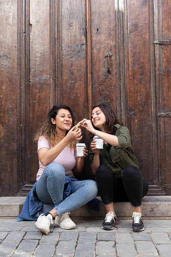 Young women sharing cookies with coffee