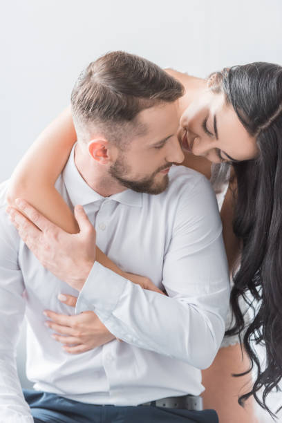 istock cheerful girlfriend hugging bearded happy boyfriend at home 1151381380