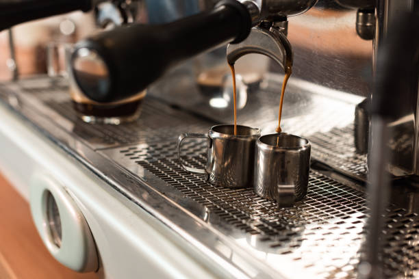 istock Selective focus of coffee machine and two stainless cups 1151381487