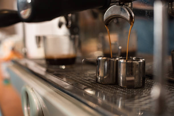 istock Selective focus of coffee machine and two stainless cups 1151381506