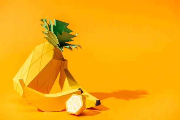 istock handmade paper pineapple, bananas and lemon on orange with copy space 1151381885