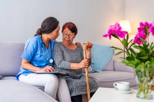 istock Young carer supporting senior disabled woman with walking stick 1151384189