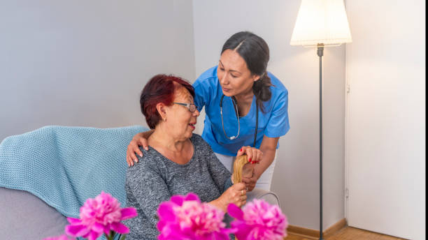 istock Nurse talking with elderly woman in light room 1151388744