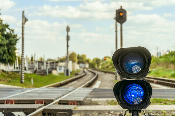 Railway traffic light with a blue standard signal. Semaphore on railroad crossing on a blurred background. Railway Infrastructure. Selective focus.