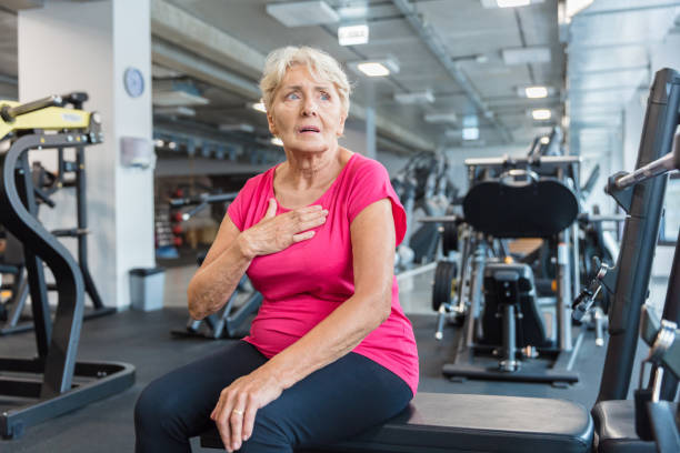 senior woman having a chest pain at rehab centre - old senior adult women tired imagens e fotografias de stock