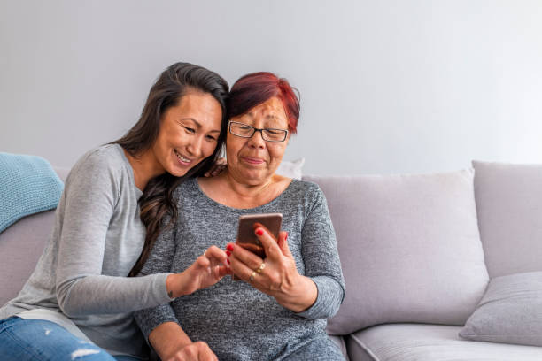istock Pleasant smiling mother and daughter using cell phone. 1151392524