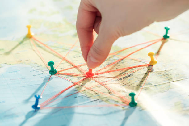 istock Partial view of woman with push pins, strings and world map 1151398880