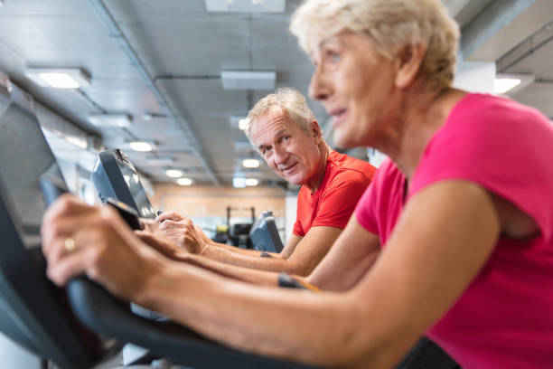istock Senior people exercising on cycling machines at gym 1151399092