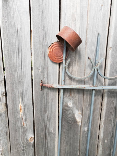 istock A rusty tin can hangs on an old wooden fence. Concept. 1151399132