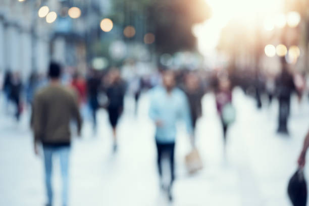 istock Unrecognizable people in bokeh walking along a evening street. Blurred image 1151399378