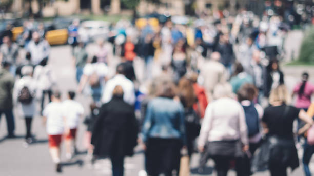 istock Unrecognizable people in bokeh walking in the city. Defocused image 1151399381