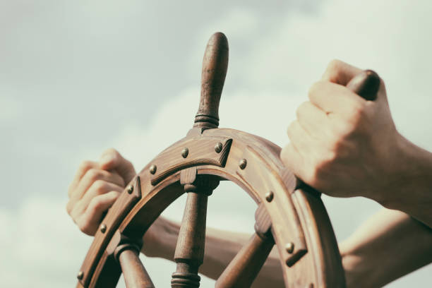 Steering hand wheel ship on sky background Steering hand wheel ship on sky background navigational equipment stock pictures, royalty-free photos & images
