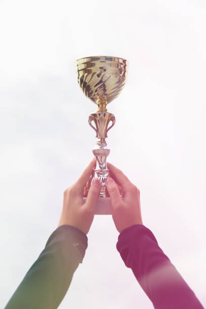 istock Woman holding gold trophy cup 1151402568