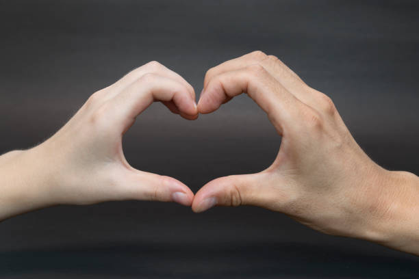 istock Hands shaped in heart on black background 1151402666