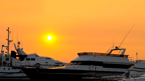 Yachts on orange sunset in Manila Bay, Philippines