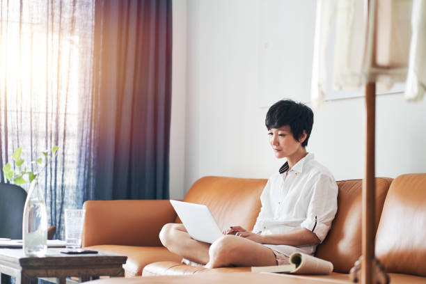 freelance asiatica che lavora su laptop a casa - laptop adult curtain business foto e immagini stock
