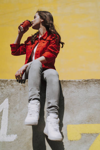 istock Young hipster girl drinking coffee on parapet 1151404879