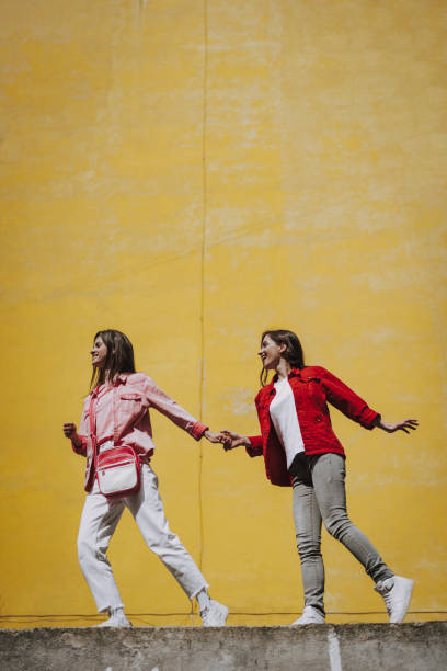 istock Two hipster girls walking together on parapet 1151404882