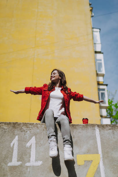istock Young trendy smiling pretending to fly on parapet 1151404899