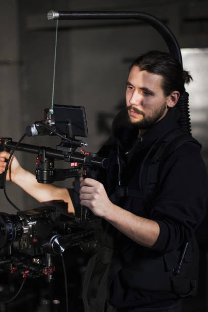 istock Professional videographer holding camera on 3-axis gimbal. Videographer using steadicam. Pro equipment helps to make high quality video without shaking. 1151405045