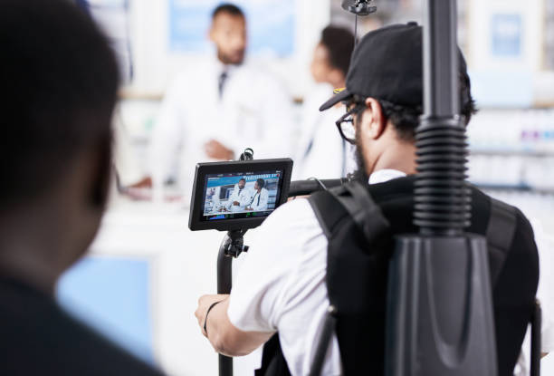 And action! Rearview shot behind the scenes of a camera crew shooting two pharmacists working inside of a pharmacy film crew photos stock pictures, royalty-free photos & images