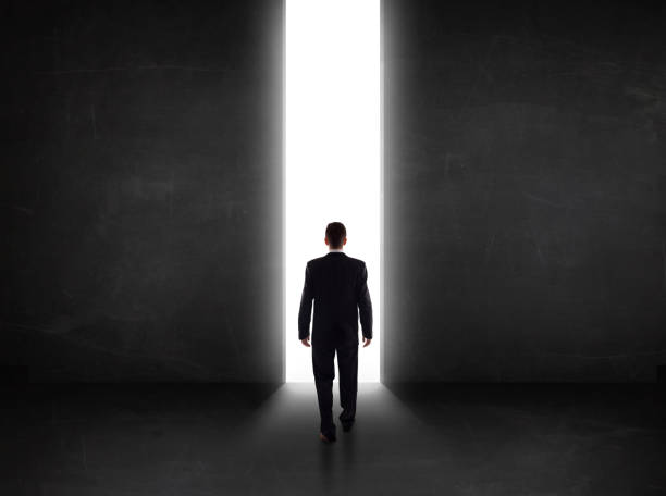 istock Business person looking at wall with light tunnel opening 1151408056