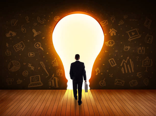 istock Business man looking at bright light bulb in the wall 1151408192