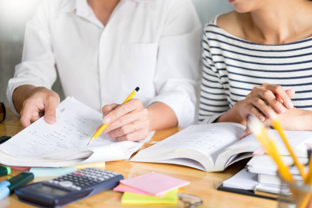 istock Midsection Of Friends Studying On Desk 1151416875