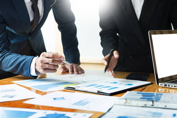 istock Midsection Of Businessman And Colleague Working Over Graph On Table 1151418638