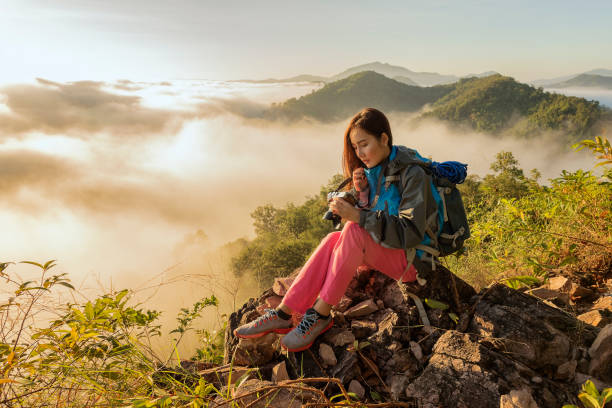 istock tourist standing on cliff in front of a sunset 1151419813