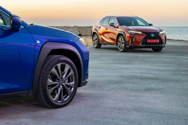 Lexus UX 250h vehicles during the daybreak Sitges, Spain - 26th February, 2019: Lexus UX vehicles in hybrid version parked on the road next to the shoreline. The UX model is the smallest crossover in the Lexus offer. 2019 stock pictures, royalty-free photos & images