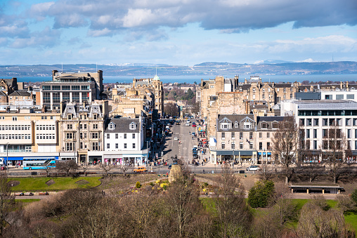 View of Edinburgh city centre on a sunny winter day. The firth of Forth and the mountains are visible in background while Princes strret park is visible in foreground. Scotland, UK.