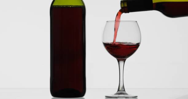 istock Rose wine. Red wine pour in wine glass over white background 1151423450