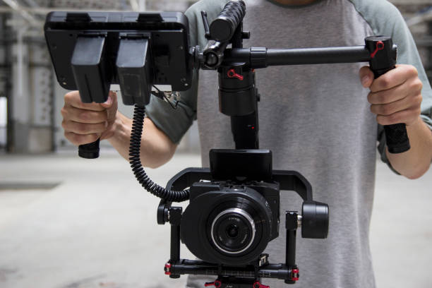 istock Professional videographer holding camera on 3-axis gimbal. Videographer using steadicam. Pro equipment helps to make high quality video without shaking. 1151423505