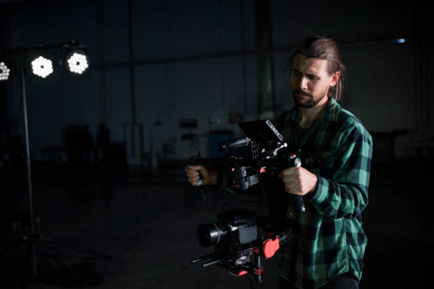 istock Professional videographer holding camera on 3-axis gimbal. Videographer using steadicam. Pro equipment helps to make high quality video without shaking. 1151423766