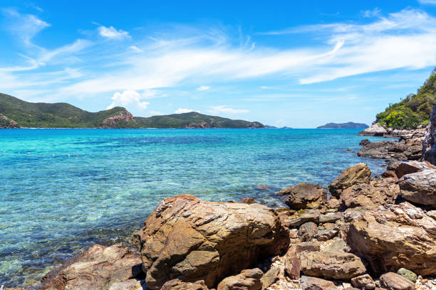 istock Large rocks on beach with clear turquoise sea background 1151423953